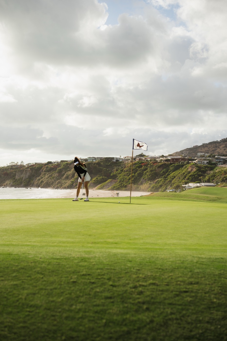 Golfer putting on an oceanfront green
